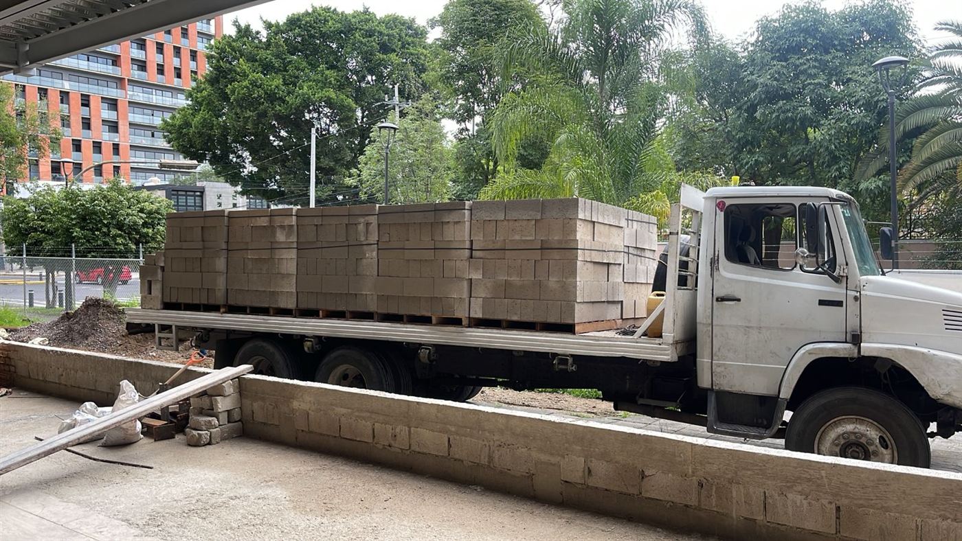 Camión con tarimas de block entregando en obra