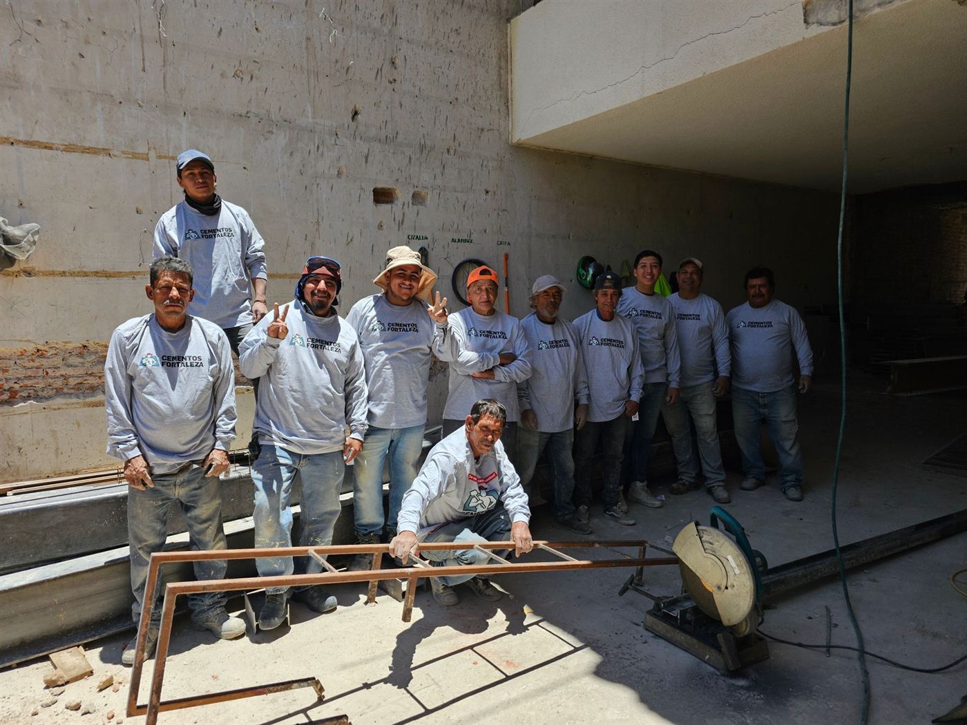 Cuadrilla de obra con playeras de Cementos Fortaleza posando en la construcción